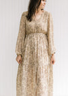 Model wearing a v-neck tan maxi with a microfloral print, elastic waist and split front. 