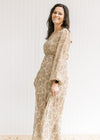 Model wearing a tan maxi with a microfloral print, bubble sheer long sleeves and a sheer overlay. 