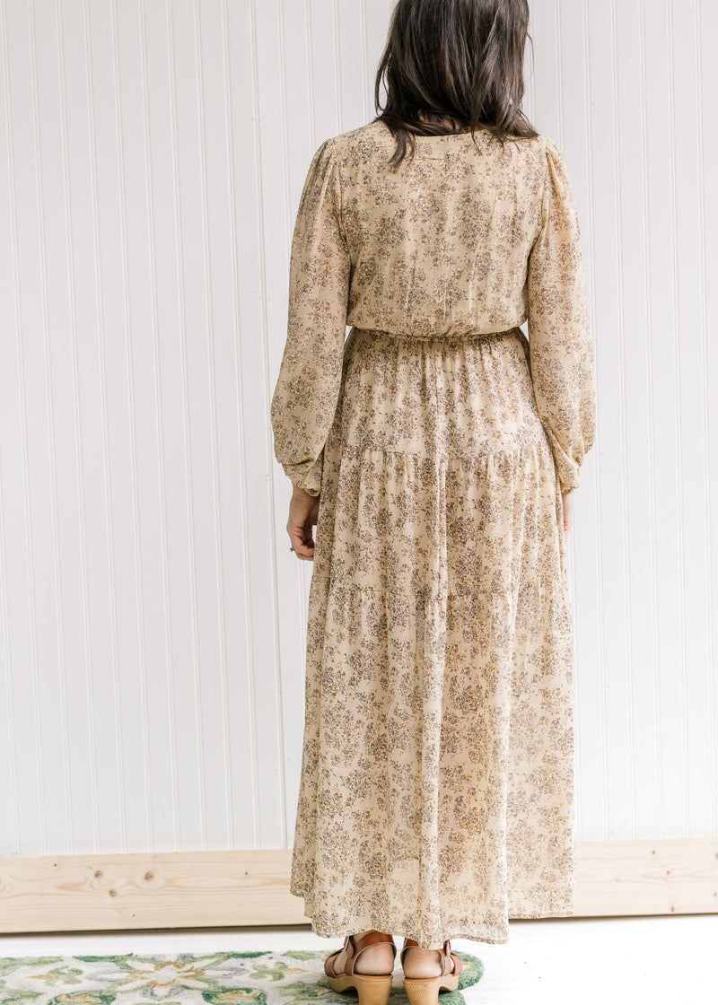 Model wearing a tan maxi with an elastic waistband, sheer overlay and sheer bubble long sleeves. 
