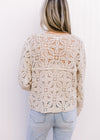 Back view of Model wearing a taupe floral crochet cardigan with a button front and long sleeves. 
