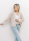 Model wearing a taupe button up cardigan with floral crochet, long sleeves and buttons. 