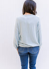 Back view of Model wearing a light blue sweater with a classic fit, long sleeves and a round neck. 