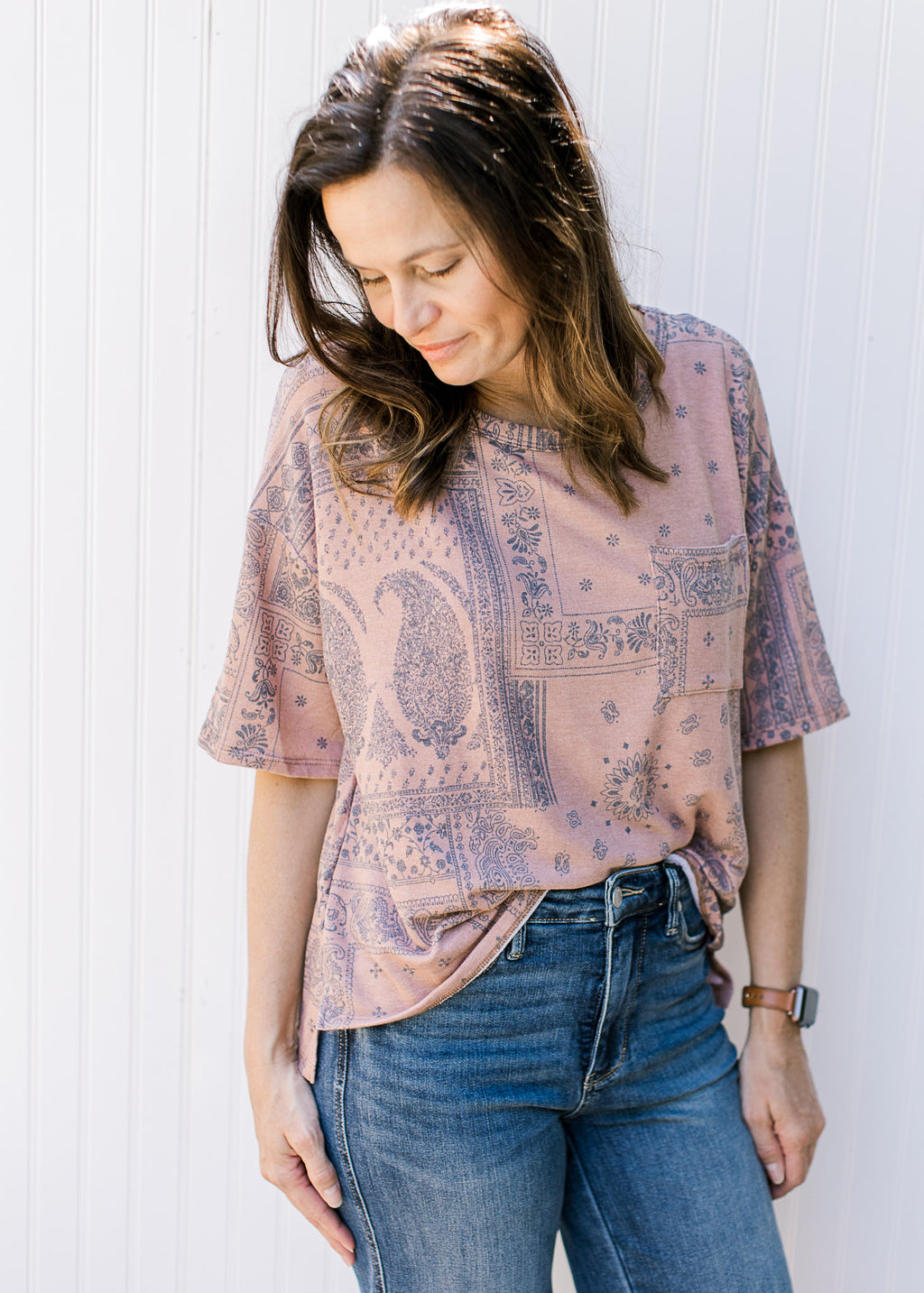 Model wearing a light brown top with a navy southwestern print, short sleeves and a round neck.