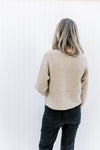 Back view of Model wearing a champagne sweater with long sleeves, a v-neck and sparkles woven in.