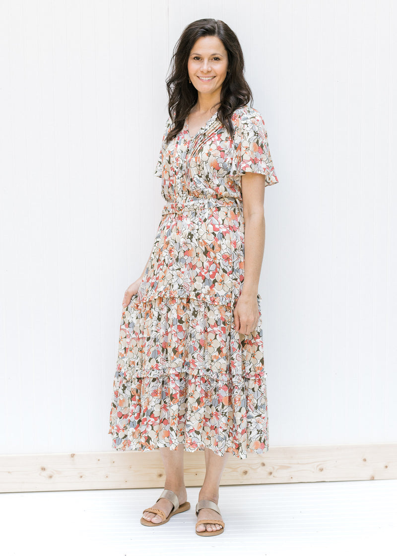 Model wearing sandals with a midi v-neck dress with a neutral floral pattern, flutter short sleeves.