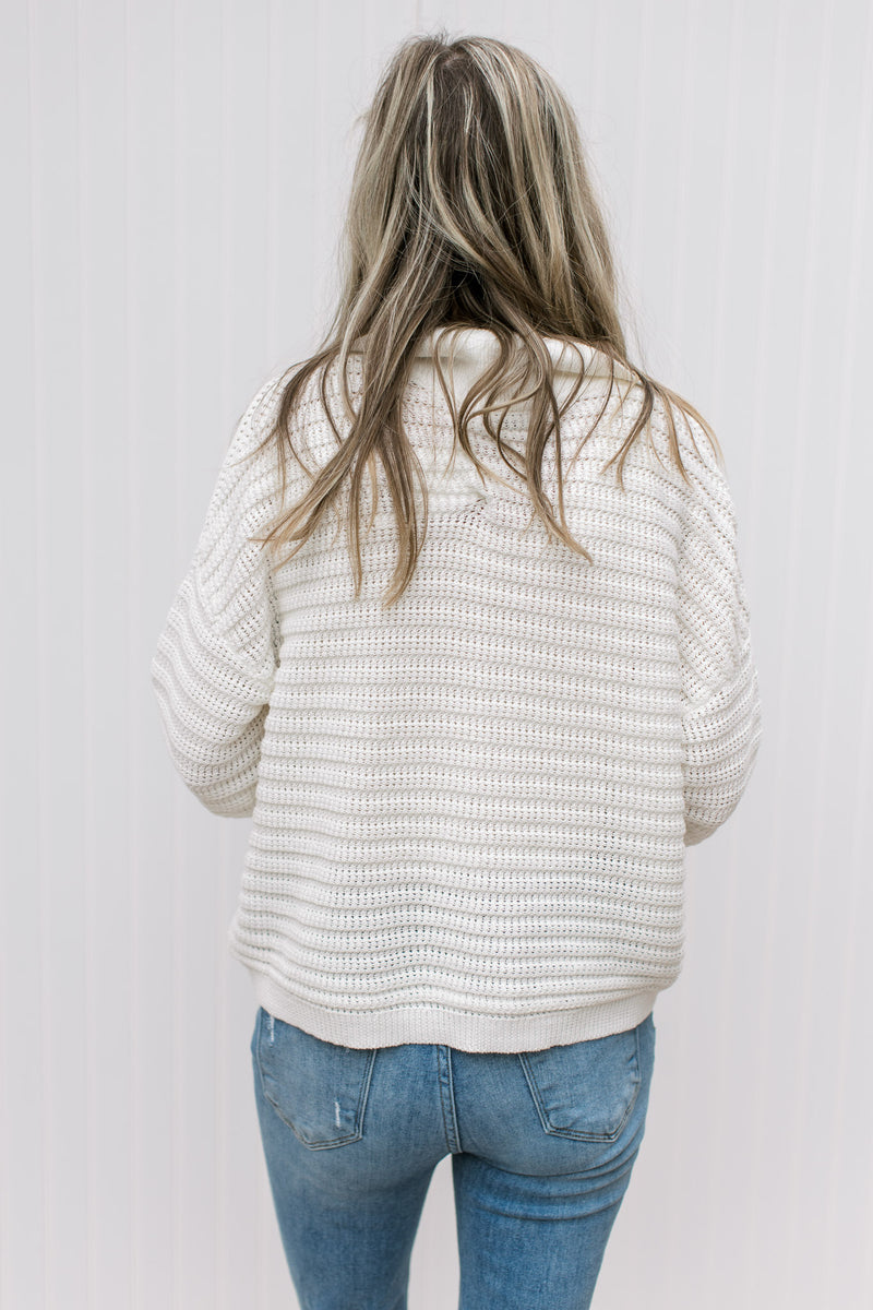 Back view of Model wearing a cream cardigan with bubble long sleeves, ribbed material and a collar.