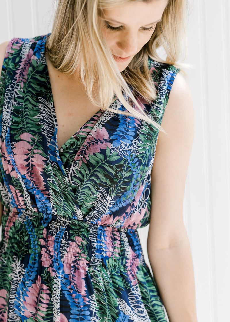 Close up of model wearing a v-neck sleeveless floral dress with an elastic waistband. 