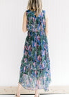 Back view of a model wearing a sleeveless maxi with a floral pattern and an elastic waist. 