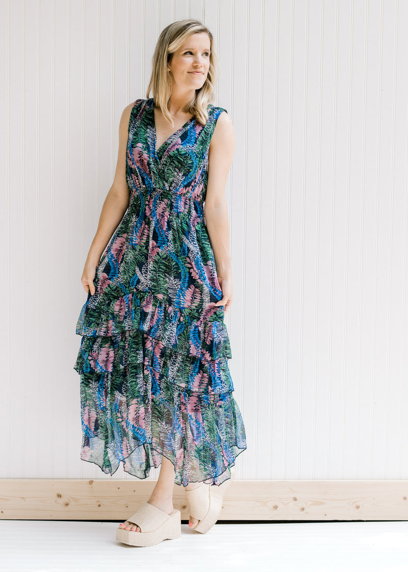 Model wearing a v-neck navy maxi with a purple, green and blue floral pattern. 