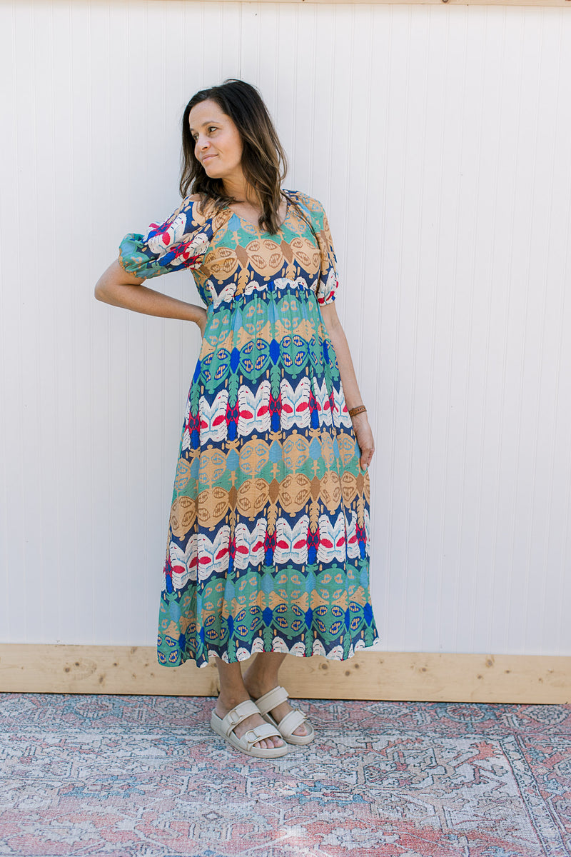 Model wearing sandals with an abstract print midi with bubble short sleeves and a v-neck. 