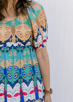 Close up of abstract print on a midi with a v-neck, bubble short sleeves and pockets. 