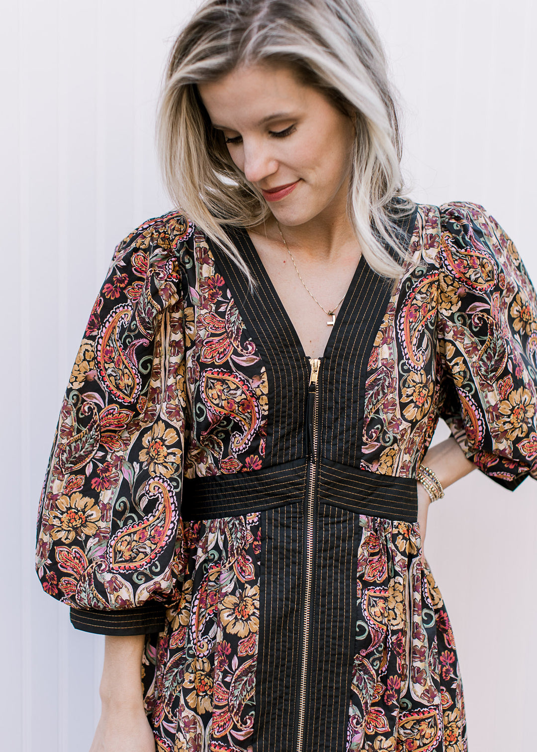 Close up of zipper and black lining on a black midi with fall floral colors, v-neck and 3/4 sleeves.