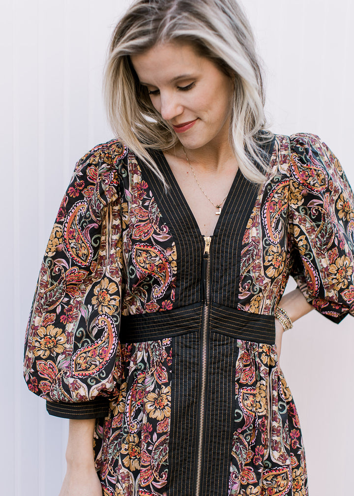 Close up of zipper and black lining on a black midi with fall floral colors, v-neck and 3/4 sleeves.