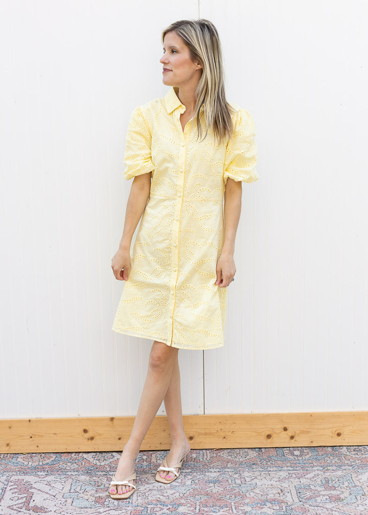 Model wearing heels and a yellow dress with eyelet overlay and bubble short sleeves. 