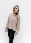 Model wearing leggings with a stone sweatshirt with a raw hemline, exposed hem and long sleeves.