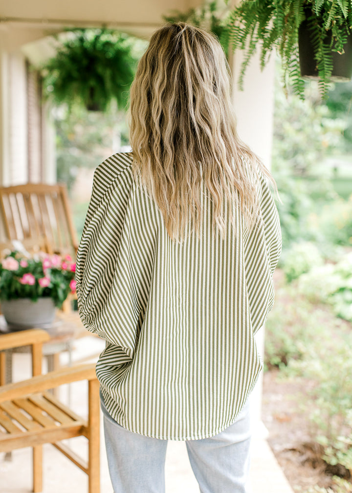 Back view of Model wearing a short sleeve olive and cream striped top with extended short sleeves.