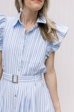 Close up of flutter cap sleeve and belt on a blue and white striped dress with a button front. 