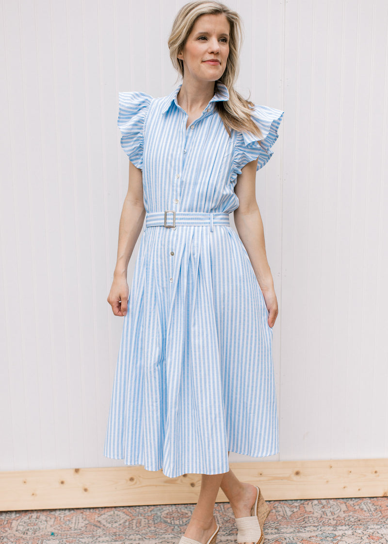 Model wearing wedges with a blue and white striped midi with flutter cap sleeves and a button front.