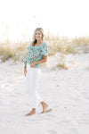 Model wearing a mixed green floral pattern top with a square neckline and short sleeves. 