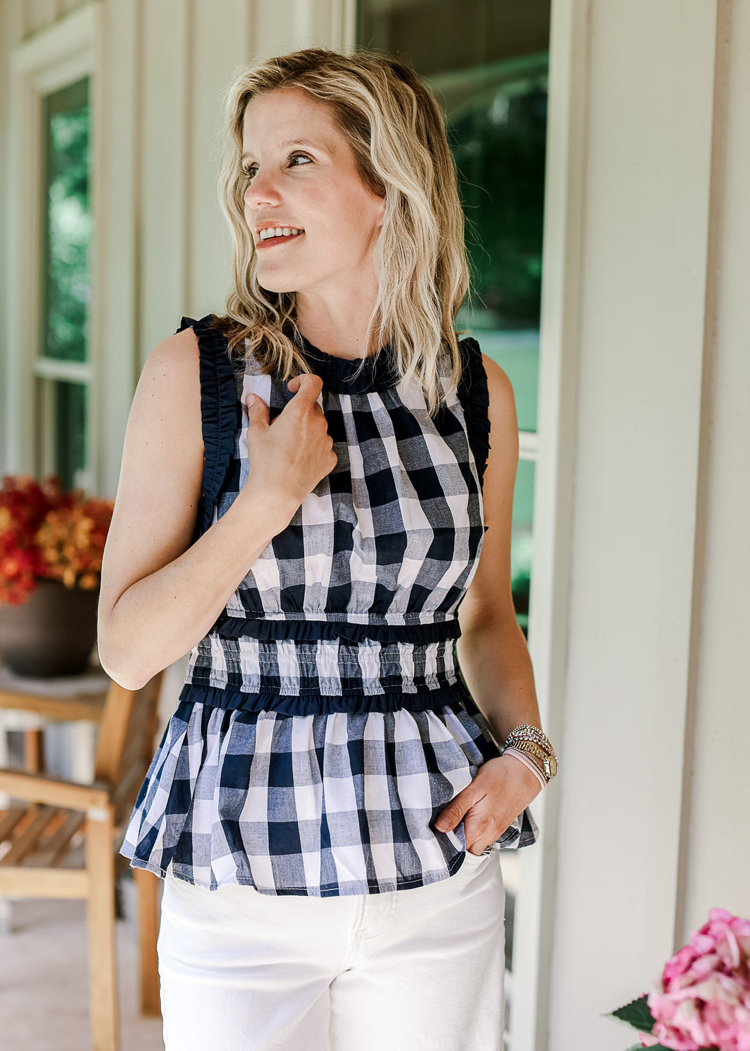 Model wearing a navy and white gingham sleeveless top with a round neck and elastic waist.