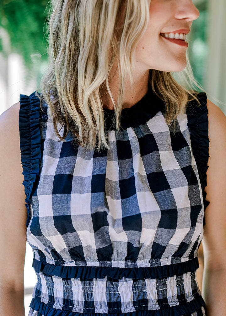 Close up of navy ruched detail at round neck and arm on a navy and white sleeveless top. 