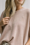 Close up view of front seam detail on a model wearing a taupe lightweight sweater with short sleeve.