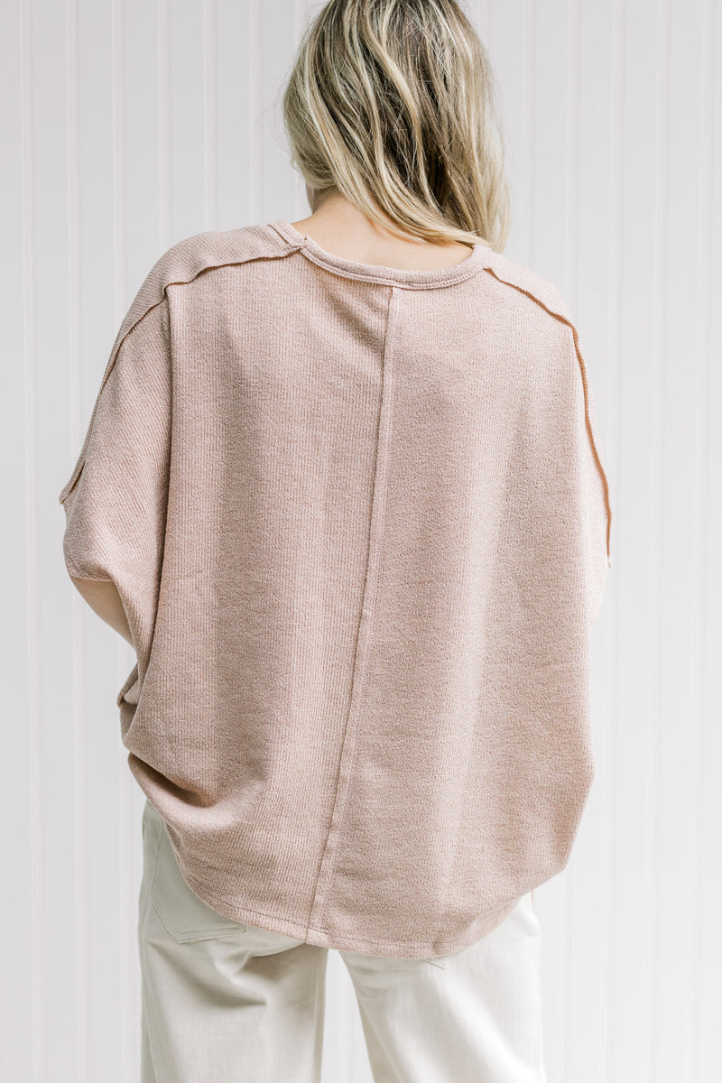 Back view of seam detail on a model in a short sleeve lightweight taupe sweater. 