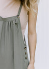 Close up of Model wearing a taupe ribbed body suit with a mocked neckline and a two snap closure. 