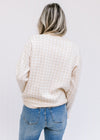 Back view of Model wearing a taupe and white checkered sweater with long sleeves and a round neck. 