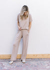 Model wearing a taupe set with a short sleeve crew neck top and wide leg bottoms. 
