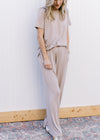 Model wearing a taupe set with a short sleeve top and wide leg bottoms with pockets. 