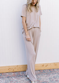 Model wearing a taupe set with a short sleeve top and wide leg bottoms with pockets. 