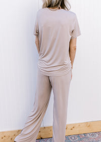 Back view of Model wearing a taupe set with a short sleeve crew neck top and wide leg bottoms.