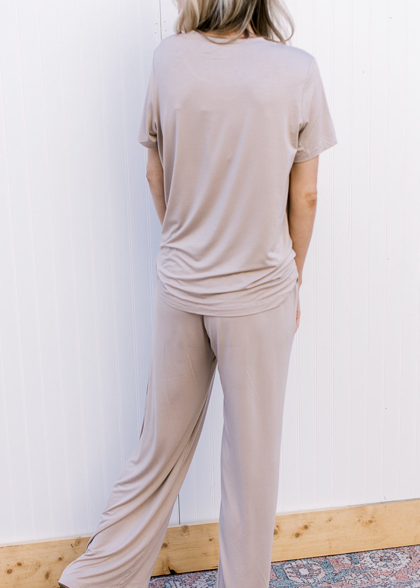 Back view of Model wearing a taupe set with a short sleeve crew neck top and wide leg bottoms.