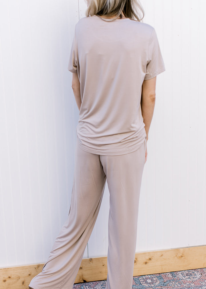 Back view of Model wearing a taupe set with a short sleeve crew neck top and wide leg bottoms.