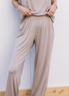 Close up of elastic band and pockets on a taupe pants with matching short sleeve top. 