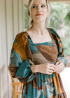 Close up of bubble long sleeves and square neck on an espresso colored dress with floral. 