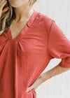 Close up of notch v-neck on burgundy above the knee dress with short sleeves and pockets. 