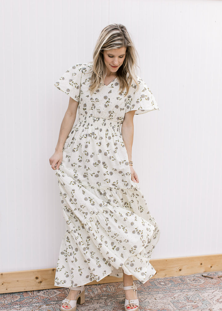 Model spinning in a cream v-neck maxi with hydrangea print, flutter short sleeves and elastic waist.