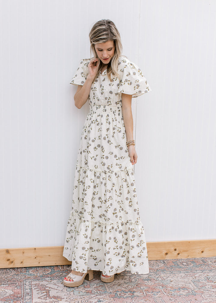 Side view of Model wearing a cream maxi with hydrangea print, short sleeves and elastic waist.