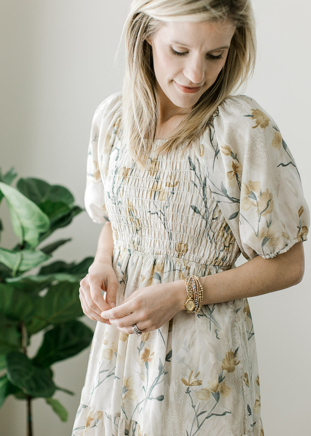 Close up of smocked bodice, short sleeves and a square neck on a cream midi with floral.