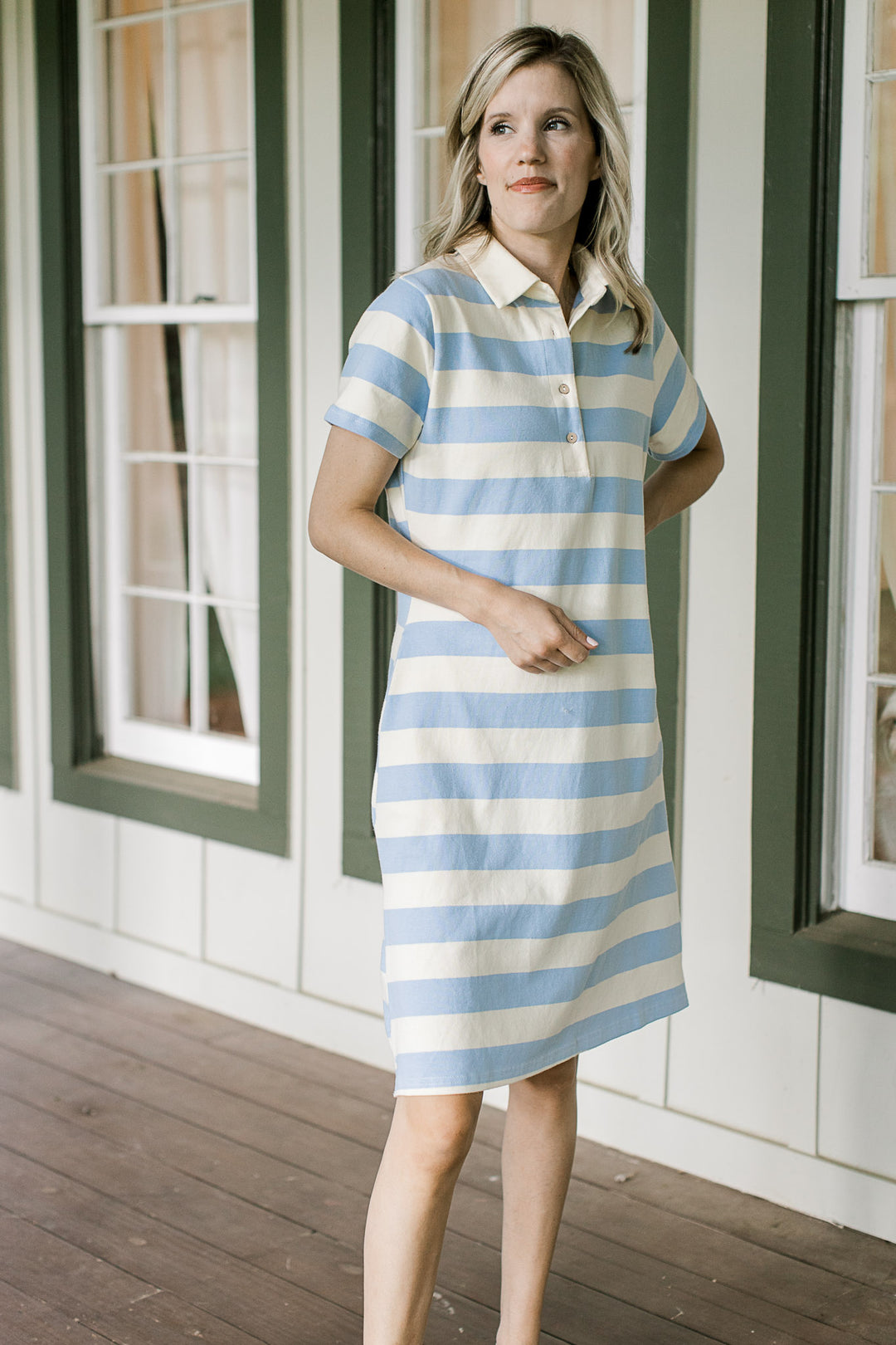 Model wearing a pale yellow and blue striped knee length dress with a collar and short sleeves. 