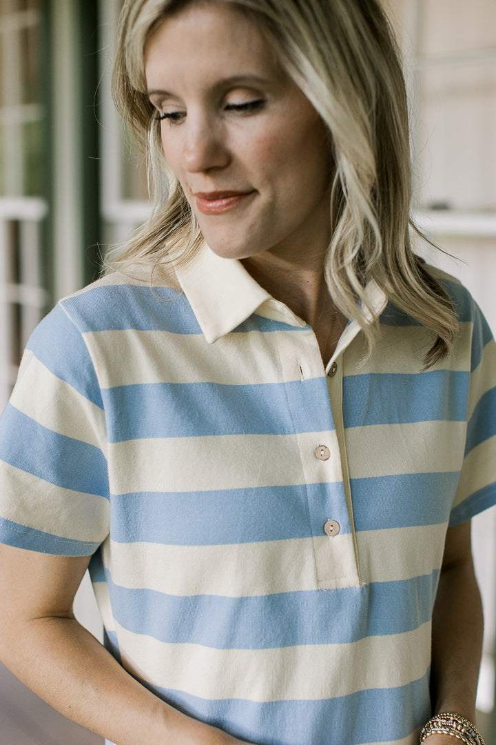 Close up of collar with three button collar on a pale yellow and blue striped short sleeve dress.