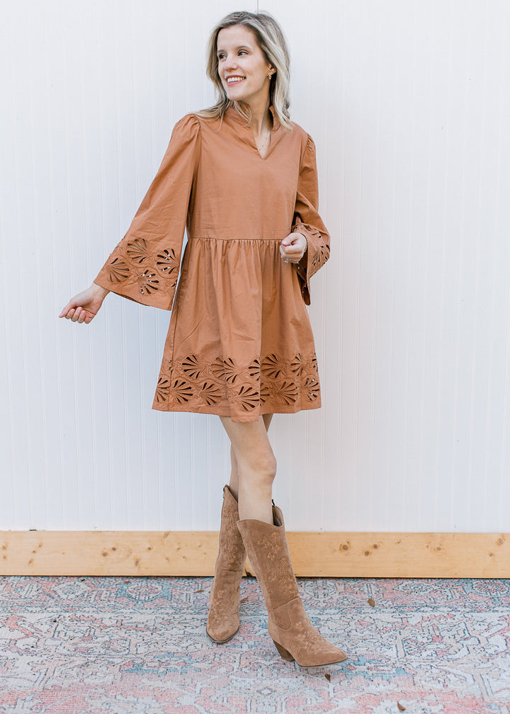 Model wearing boots and a toffee dress with a floral lace cutout at cuff and hem and 3/4 sleeves.
