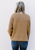 Back view of Model wearing a toffee sweater with a patch pocket, long sleeve and a round neck.