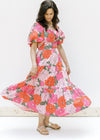 Model twirling in a coral floral midi dress with square neck, smocked back and puff short sleeves. 