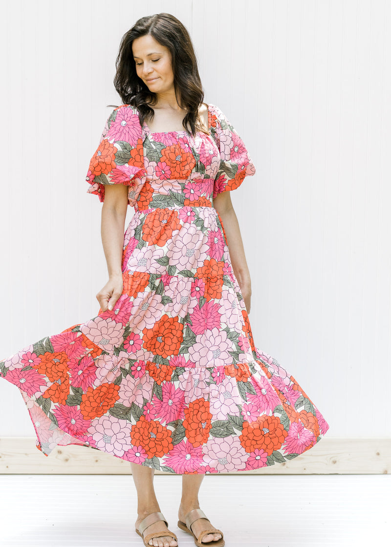 Model wearing a coral floral midi dress with a square neck, smocked back and puff short sleeves. 