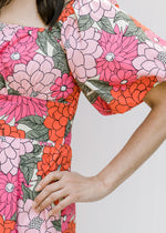 Close up of short puff sleeve on a coral floral midi dress with a square neck. 
