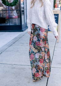 Model wearing a cream sweater and a deep sage silk fabric with warm floral and a hidden back zip.