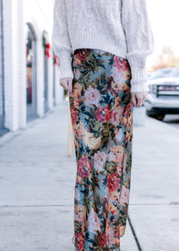 Model wearing a silky maxi with a deep sage fabric with warm floral and a hidden back zip.